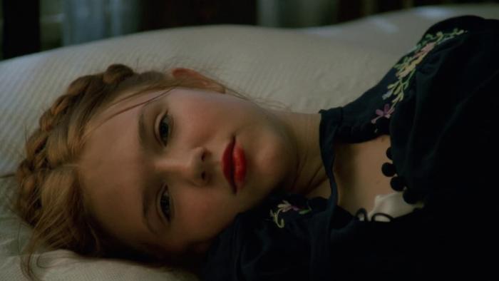 Lolita: Dominique Swain lays on a bed, only her head and shoulders seen