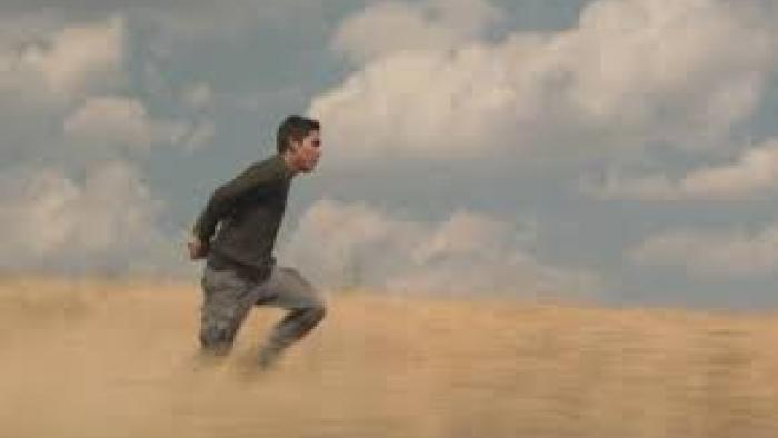 Lost in the Night:  A man walks through a field