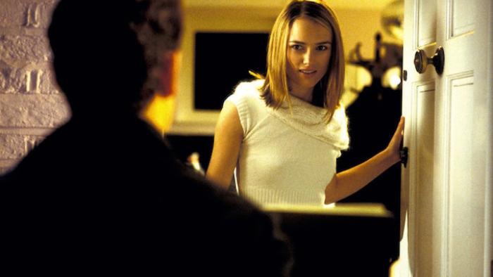 Love, Actually Movie: Keira Knightley stands in an open doorway, in the foreground is Andrew Lincoln's back.