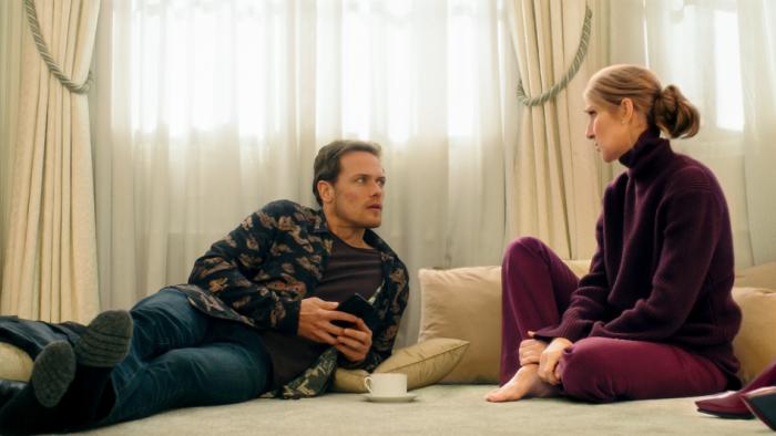 Love Again Movie: Sam Heughan lounges on the floor, propped up on his elbow, while talking to Celine Dion, who's sitting next to him