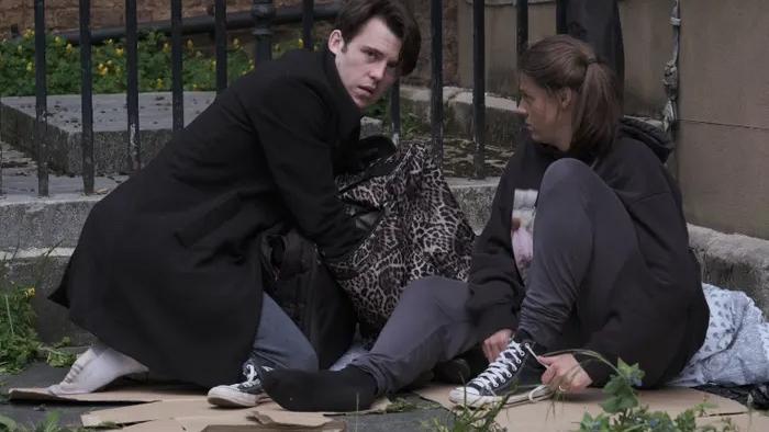 Love Without Walls: Niall McNamee crouches over, looking inside a bag, while Shana Swash sits next to him against a wall