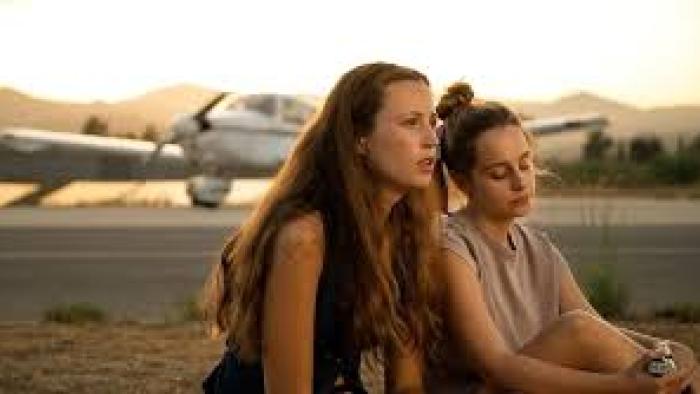 Mango: Two women look pensive by airplane