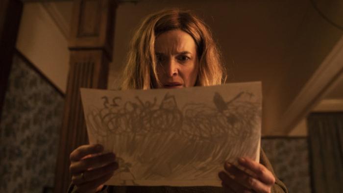 Marionette: Dr. Marianne Winter holds a piece of paper up in front of her, looking concerned.