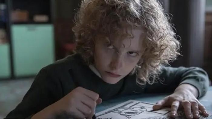 Marionette: Manny holds a crayon over a drawing, an angry look on his face.