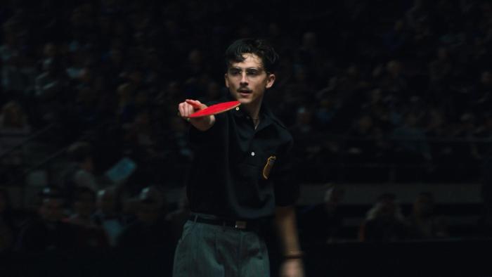 Marty Supreme movie: Marty holds a table tennis paddle and points