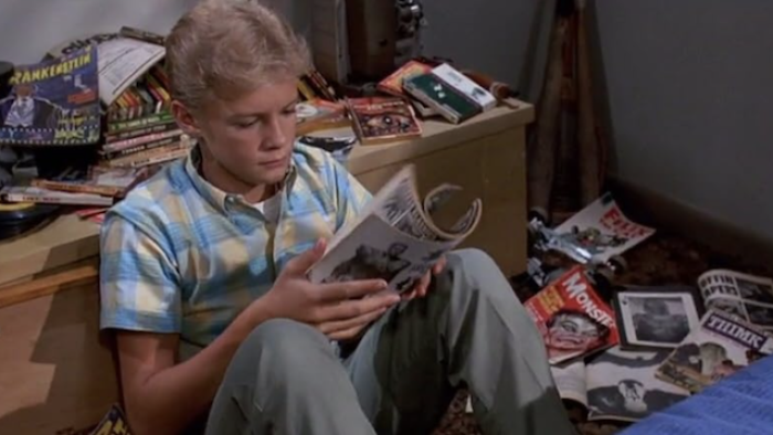 Matinee: Boy reading a magazine in a cluttered room