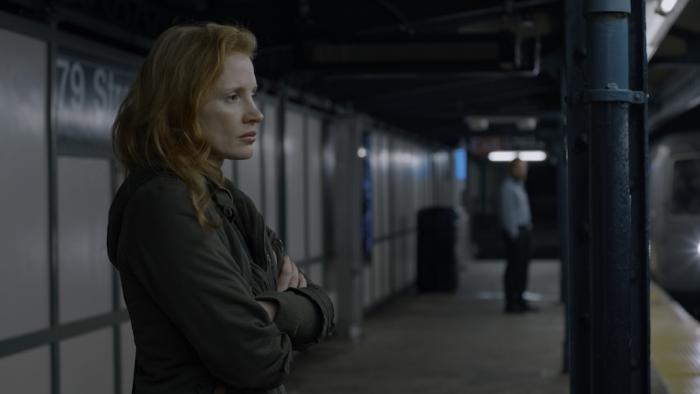Memory Movie: Sylvia (Jessica Chastain), looking uneasy, stands on a train platform, her arms crossed