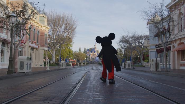Mickey walks down Main Street USA at Disneyland.