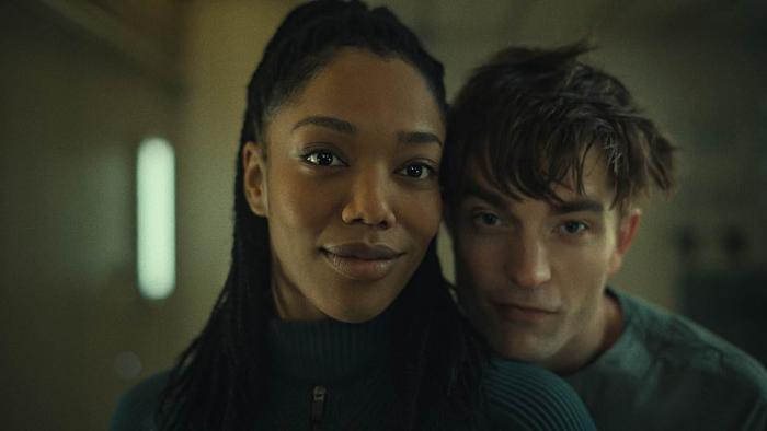 Mickey 17 Movie: Nasha and Mickey appear to be looking in a mirror, heads close together, smiling