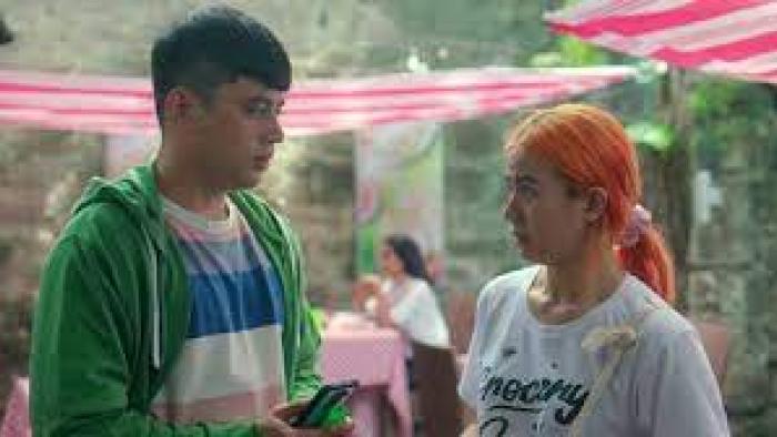 Missed Connections: Filipino young man in green hoodie on left looks at Filipino young woman with orange hair in white t-shirt on right in outdoor cafe