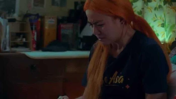 Missed Connections: Filipino young woman with orange her sits in her bedroom looking down at her laptop