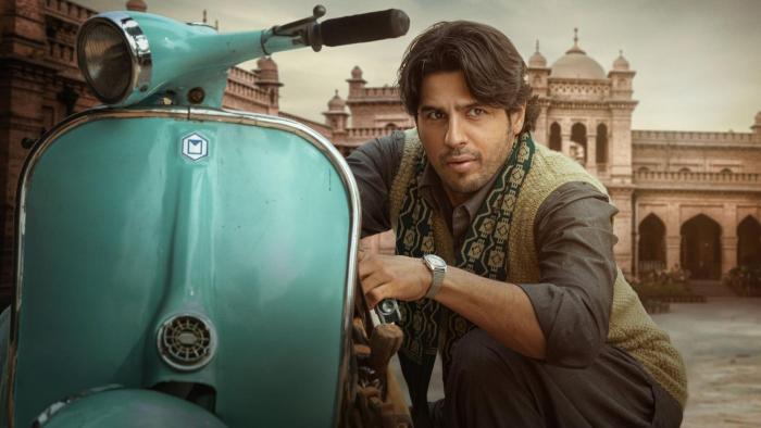 Mission Majnu: Singh crouches next to his scooter. 