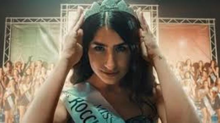 Miss Italia Musn't Die: Woman with crown and sash at pageant 