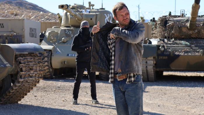 Mojave Diamonds: Jason in front of tanks. 