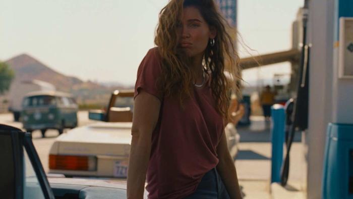 Monica Movie: A woman pumps gas with the wind in her hair