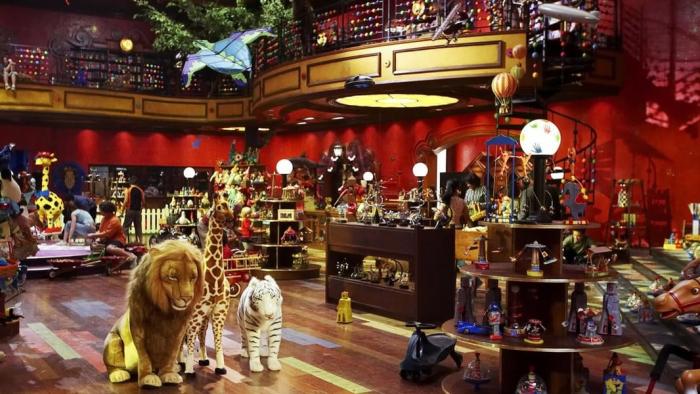 An intricate toy store filled with all kinds of items, from stuffed lions and giraffes to stands of wind-up toys. 