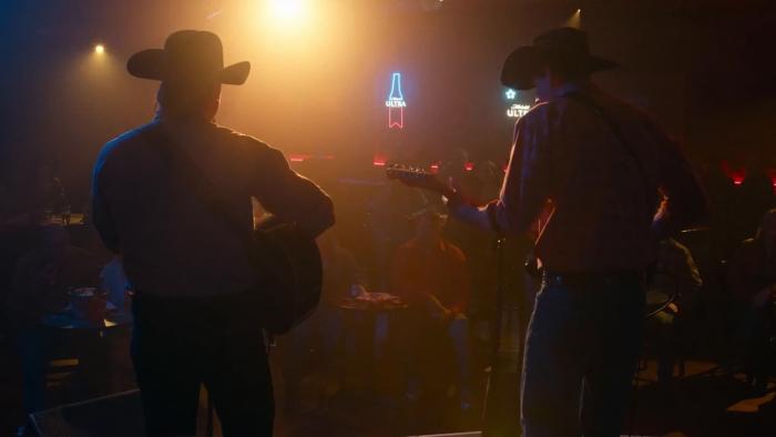 The Neon Highway Movie: Seen from behind, the Collins brothers (Rob Mayes and T.J. Power) play their song for an audience