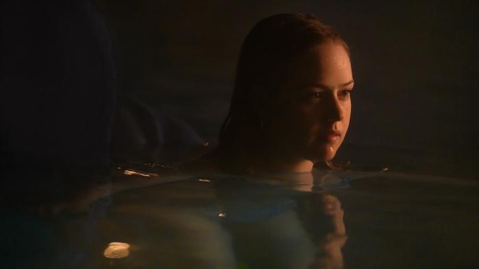 Night Swim Movie: Teen Izzy (Amélie Hoeferle), swimming in the pool at night, looks serious