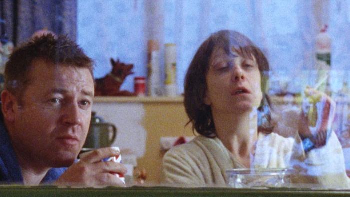 Nil by Mouth: Ray Winstone and Kathy Burke seen through a window