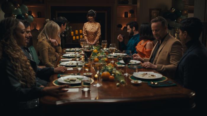 Nuked movie: Natasha Leggero as "Chef Sasha" stands proudly in front of a long table full of guests