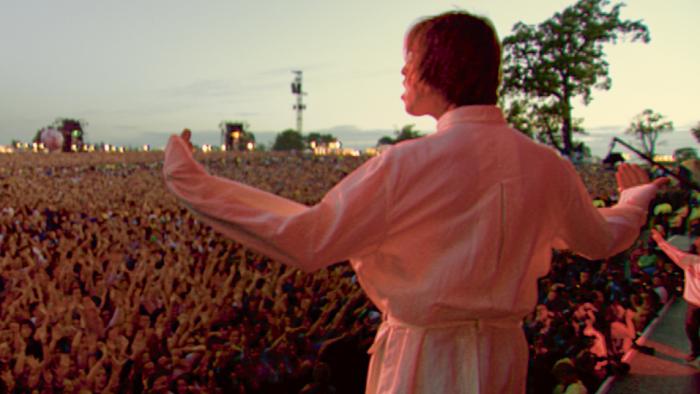 Oasis—Supersonic: Oasis singer Liam Gallagher stands on stage in front of a crowd