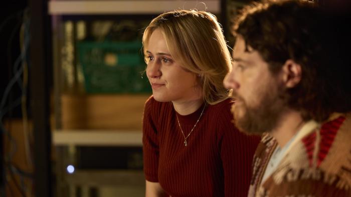 O Horizon Movie: Abby (Maria Bakalova) and Sam (Adam Pally) sit in front of a computer screen, creating Abby's AI dad