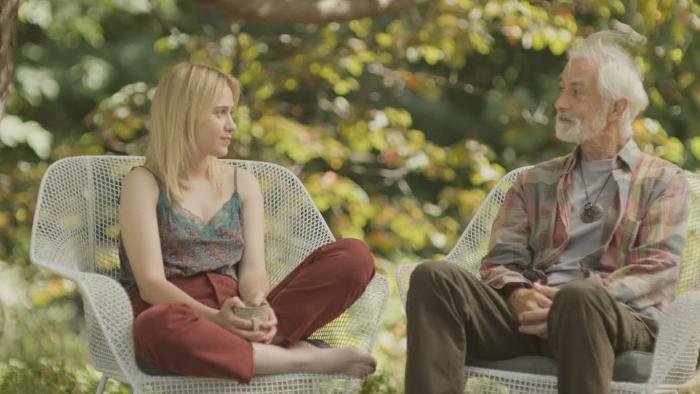 O Horizon Movie: Sitting in deck chairs, Abby (Maria Bakalova) has an emotional visit with her AI dad (David Strathairn)