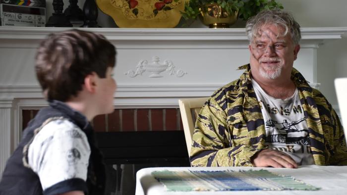 Operation Friendship: A boy looks at an older man with drawing on his face
