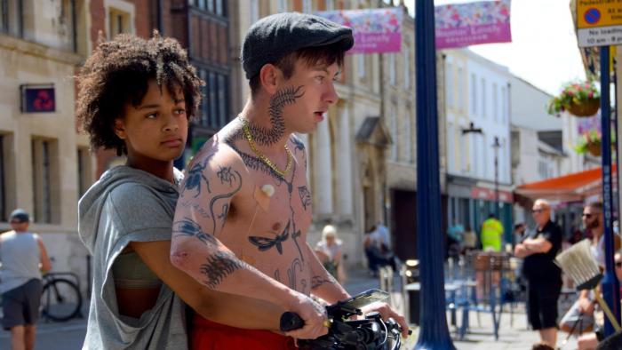 Bird: A young biracial girl and her White father riding a scooter together