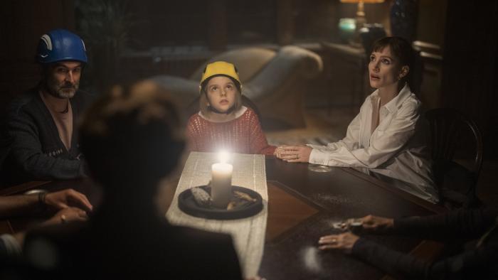 Other Mommy movie: Daddo (Jay Duplass), Bela (Arabella Olivia Clark), and Mommy (Jessica Chastain) sit around a table in hard hats during a seance