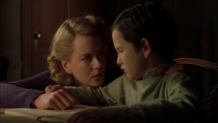 Nicole Kidman reads a book next to a child.