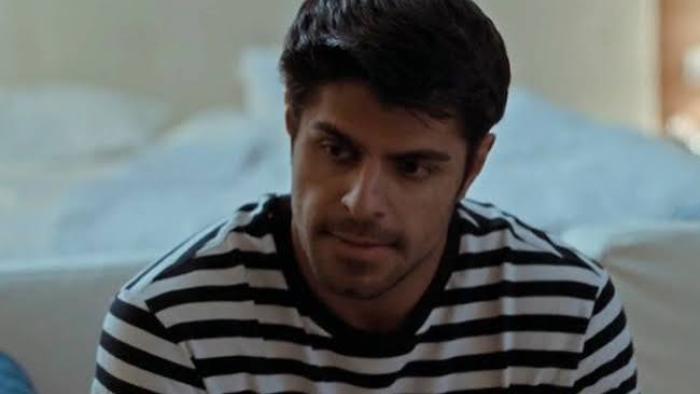 The Paradise Murders: Young man in a striped shirt looking thoughtful.