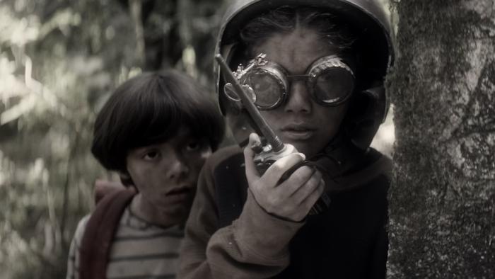Párvulos: Children of the Apocalypse Movie: Oliver, in goggles and a helmet, holds a walkie-talkie; Benny is behind him