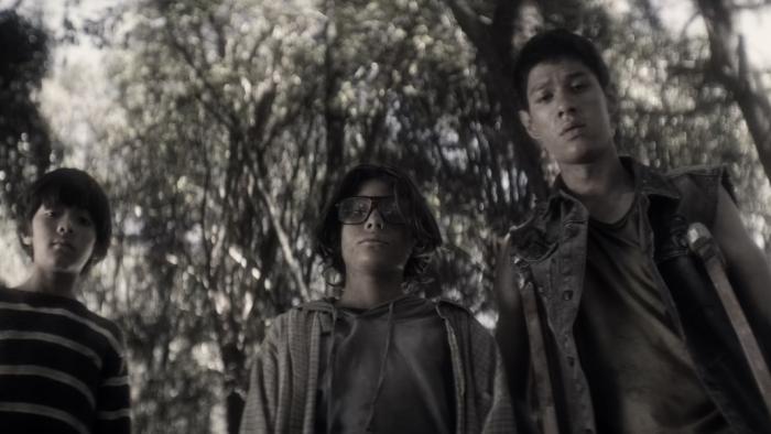 Párvulos: Children of the Apocalypse Movie: Benjamin, Oliver, and Salvador look down at something in the woods