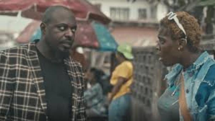 Passport: Nigerian man on left faces Nigerian woman with white sunglasses in hair on right
