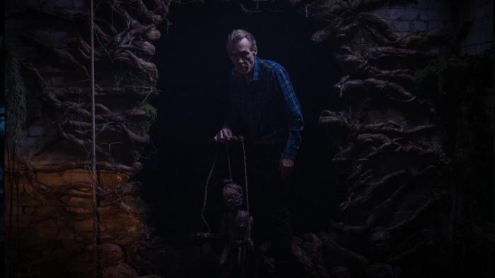 Pinocchio Unstrung Movie: Grandpa Geppetto emerges from a creepy-looking cave holding a wooden puppet