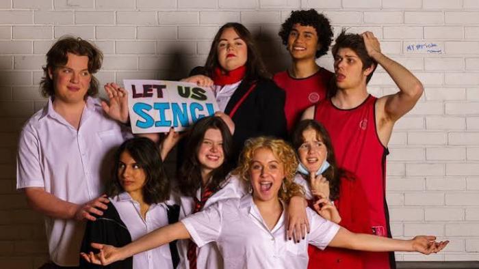 Plan Bea movie: Seven people posing against a white brick wall.