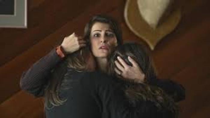 Poisoned Love: The Stacey Castor Story: Nia Vardalos holds two children, looking concerned. Brown wood wall background.