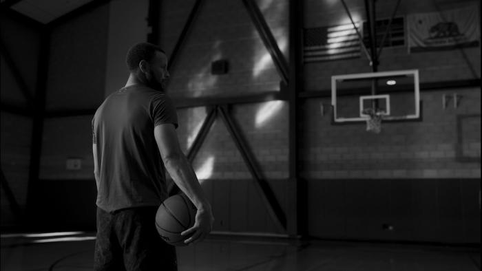 Portrait of an Artist: Stephen Curry Movie: In a black-and-white image, Curry prepares to practice a three-point shot
