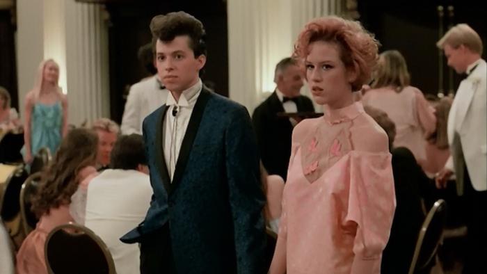 Pretty in Pink Movie: Duckie and Andie at prom looking suspiciously at someone off screen