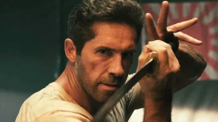 Prisoner of War: A White man in a white t-shirt holding a Japanese sword