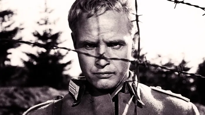The Young Lions: Marlon Brando peering through barbed wire