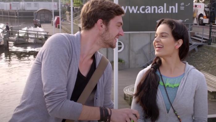 Queen: An Indian woman and a White man share a joke.