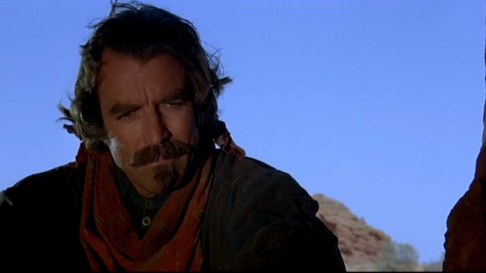 Quigley Down Under: Tom Selleck sits by cave