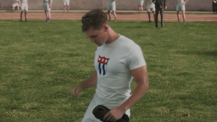 Raising the Bar: The Alma Richards Story movie: Paul Wuthrich kneels on the ground holding a hat