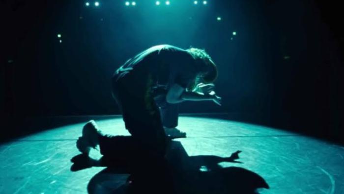 Untold Raygun: Breaking Badly movie: Rachael Gunn crouches on stage as we see her shadow.