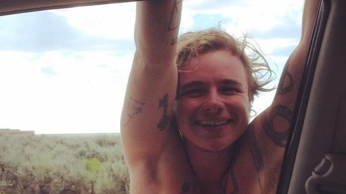 Real Boy Movie: Bennett Wallace hangs on the doorframe of a car, shirtless and smiling