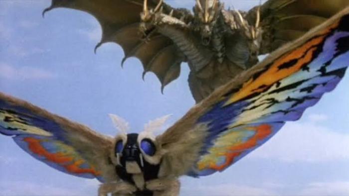 Rebirth of Mothra III Movie: Fantasy creatures, a colorful giant moth and a dragon, against a blue sky.