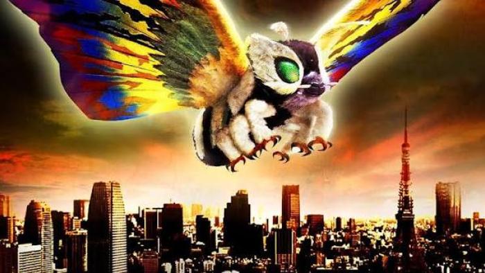 Rebirth of Mothra III Movie: Colorful giant moth flying over a city skyline at sunset.