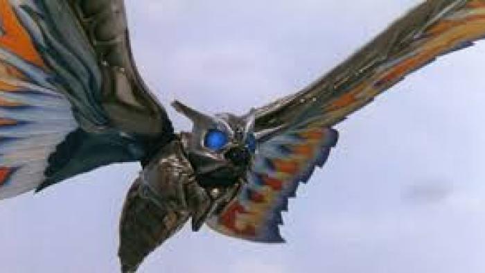 Rebirth of Mothra III Movie: A large robotic moth with colorful wings in flight against a cloudy sky.